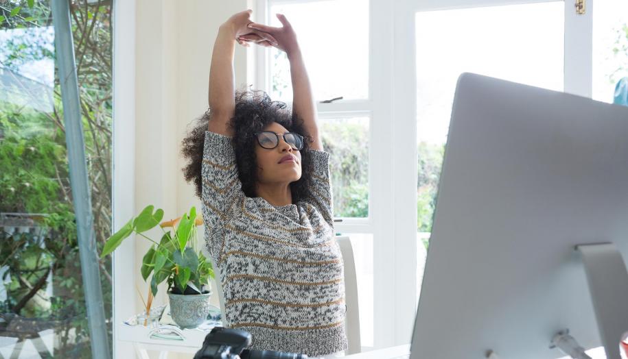 Image: Woman stretching at desk