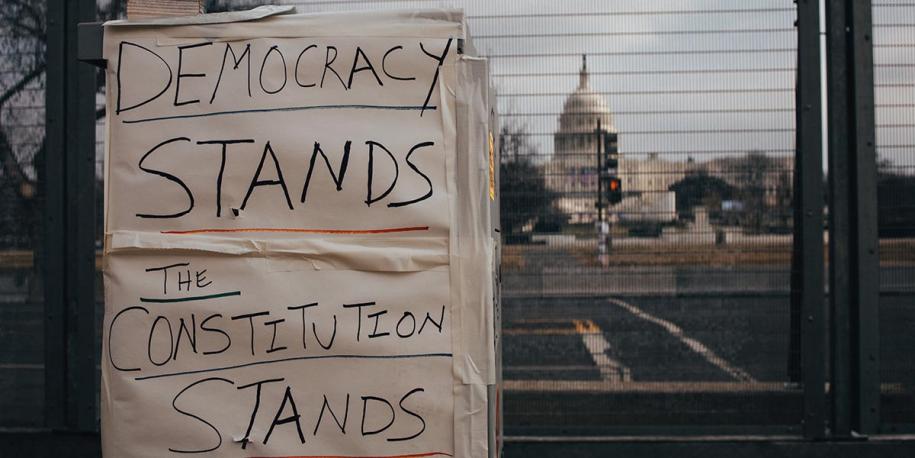 Photo: US Capitol Building with sign reading "Democracy Stands, the Constitution Stands" by Brendan Beale on Unsplash